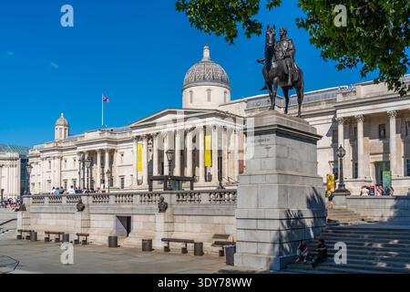 Besucher genießen einen warmen Sommertag an der Reiterstatue von König Georg IV. Und der National Gallery am Trafalgar Square Stockfoto