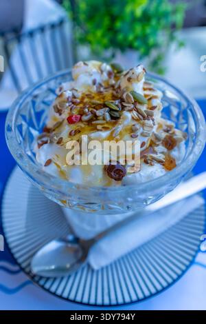 Genießen Sie griechischen Joghurt mit Honig und Samen in einer Schüssel in einem lokalen Restaurant auf Kreta, Griechenland Stockfoto