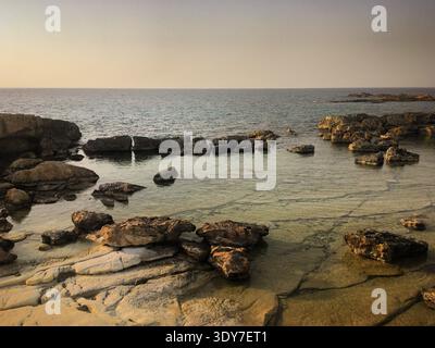 Ruhige felsige Küste in der Abenddämmerung in der Nähe von Pégeia, Paphos, Zypern, November 2018 Stockfoto