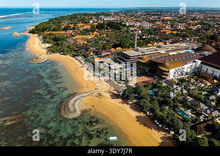 Drohnenaufnahme der Küste von Sanur, die den Strand, das Riff und die Resortentwicklung zeigt Stockfoto