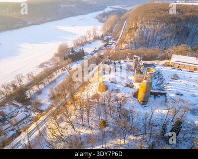 Aus der Vogelperspektive sehen Sie die Ruinen der Burg Zviretice im Winter. Schnee bedeckt die Landschaft und Bäume. Die Szene fängt die historische Stätte ein, umgeben von einer weißen Schneedecke. Stockfoto