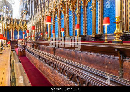 Besucher sehen den Quire in der Westminster Abbey in London. Der Bereich verfügt über Chorstände und dekorative Elemente. Viele kommen, um die Architektur und die reiche Geschichte zu bewundern. Stockfoto