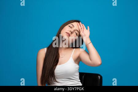 Junge Frau mit Kopfschmerzen oder Migräne, Müdigkeit und Stress, Schmerzen und Erschöpfung Stockfoto