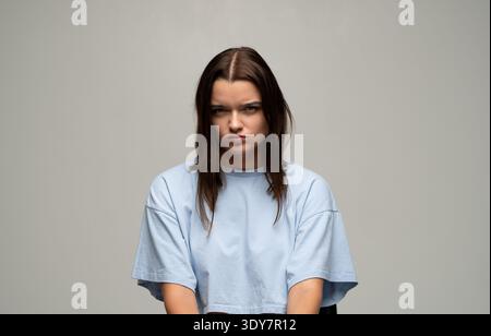 Eine junge Frau mit einem wütenden, mürrischen und frustrierten Ausdruck, der sich genervt, aufgebracht fühlt, und Unzufriedenheit Stockfoto