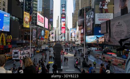Eine lebhafte Tagesszene am Times Square in New York City, die den belebten fußgängerplatz mit Leuten zeigt, die gehen, sitzen und Fotos machen. Stockfoto