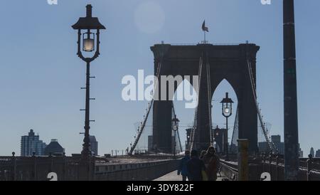 Ein Blick auf den Fußgängerweg der Brooklyn Bridge, der die berühmten Steintürme mit ihren gotischen Bögen zeigt, die sich deutlich über dem Wald erheben. Stockfoto