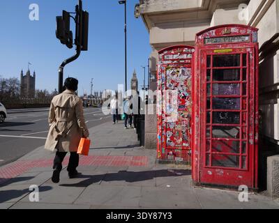 Zwei ikonische rote K6-Telefonkästen auf der Südseite der Westminster Bridge in London sind im März 2026 stark mit verschiedenen Aufklebern bedeckt. Diese an der Lambeth Palace Road in der Nähe des St. Thomas' Hospital gelegenen Kioske, die 1935 von Sir Giles Gilbert Scott entworfen wurden, sind zu einem Magnet für „Sticker Bombardierung“ und Street Art geworden Stockfoto