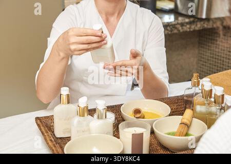 Weibliche Kaukasische Erwachsenenlotion Im Spa-Setting Mit Verschiedenen Hautpflegeprodukten Auf Dem Tablett. Stockfoto