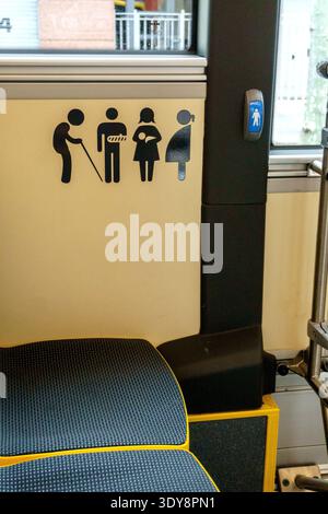 Symbole für vorrangige Sitzplätze für ältere Menschen, Schwangere, Verletzte und Personen mit Kind in öffentlichen Verkehrsmitteln, Nahaufnahme mit Sitz und Verkleidung Stockfoto