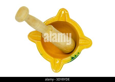 Ansicht von oben nach unten eines gelben Keramikmörtels mit einem Holzstößel auf weißem Hintergrund Stockfoto