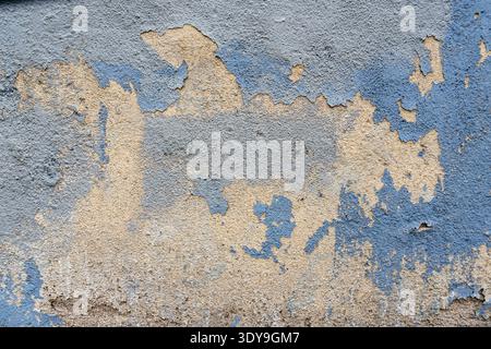 Beschädigte und abblätternde Hausfassade mit Ziegeln Stockfoto