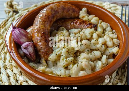 Butifarra mit Bohnen, Botifarra amb Mongetes oder Botifarra amb Seques ist ein traditionelles Gericht der katalanischen Küche, basierend auf Butifarra und weißen Bohnen. Stockfoto