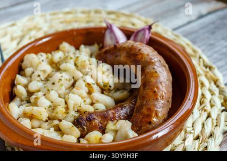 Butifarra mit Bohnen, Botifarra amb Mongetes oder Botifarra amb Seques ist ein traditionelles Gericht der katalanischen Küche, basierend auf Butifarra und weißen Bohnen. Stockfoto
