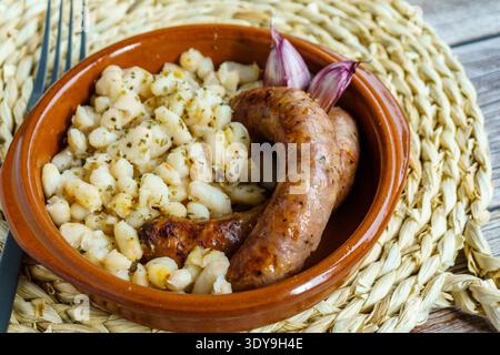 Butifarra mit Bohnen, Botifarra amb Mongetes oder Botifarra amb Seques ist ein traditionelles Gericht der katalanischen Küche, basierend auf Butifarra und weißen Bohnen. Stockfoto