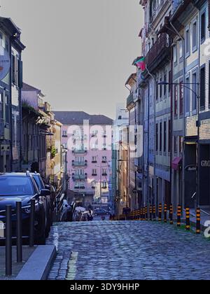 Kopfsteinpflasterstraße im historischen Porto, Portugal, mit farbenfrohen Gebäuden. Stockfoto