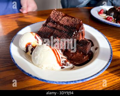 Schokoladenkuchen serviert mit Vanilleeis als Teil eines Pub-Lunch Stockfoto