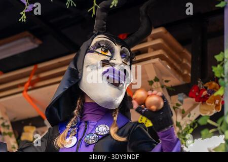 Basel, Schweiz - 25. März 2026: Maskierter Karnevalsdarsteller wirft Zwiebeln aus einem geschmückten Paradewagen während der Basler Fasnacht 2026 in Stockfoto