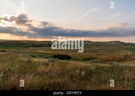 Die Prärie des Grasslands National Park erstreckt sich in weiter entfernten Badlands in der tieferen Abenddämmerung. Stockfoto