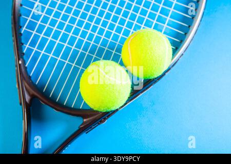 Tennisschläger und -Bälle auf blauem Hintergrund. Nahaufnahme. Stockfoto