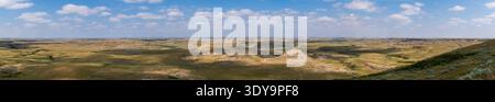 Farbenfrohe geologische Schichten umhüllen die erodierten Buttes und Coulees im Grasslands National Park und bilden eine dramatische Landschaft. Stockfoto