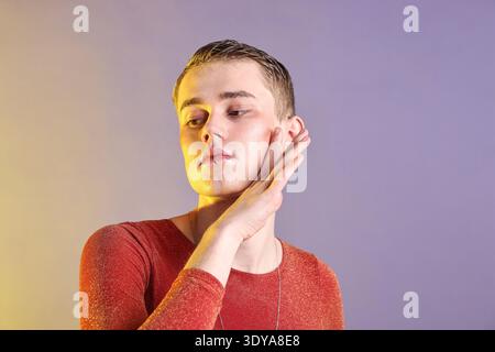 Junger Mann mit Piercing in stilvollem Hemd auf farbigem Hintergrund Stockfoto