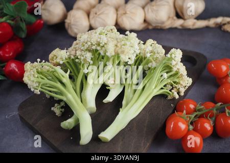 Frisches Gemüse auf einem hölzernen Schneidebrett mit Knoblauch Stockfoto