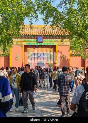 September 2025 - Peking, China: Eine geschäftige Szene im Yonghegong Lama Tempel in Peking, China, mit einem leuchtenden roten Tempeltor und einer großen Menschenmenge Stockfoto