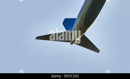 Niedrigwinkelansicht eines kommerziellen Flugzeughecks, das gegen einen klaren blauen Himmel fliegt Stockfoto