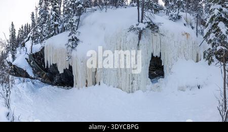 Lange gefrorene Eiszapfen hängen von einer Klippe am Great Slave Lake und erschaffen eine Höhle in Yellowknife, Kanada Stockfoto