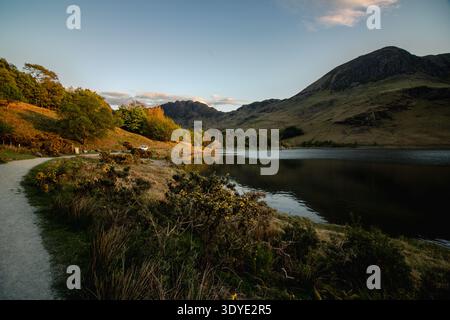Blick auf Buttermere auf Seehöhe mit Rolling Fells und Golden Sky. Buttermere, Lake District, Cumbria, Großbritannien Stockfoto