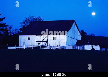 Der Vollmond steigt über die ländliche Scheune von Pennsylvania und die Felder von Bauernhöfen auf Stockfoto