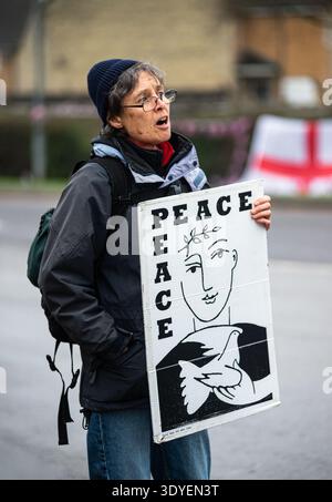 RAF Fairford, Gloucestershire, 7. März 2026. Eine Dame hält ein Plakat hoch, während sie an einem Antikriegsprotest bei der RAF Fairford teilnimmt Stockfoto