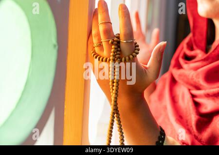 Nahaufnahme von muslimischen Frauenhänden, die während des Gebets Gebetsperlen trugen. Stockfoto