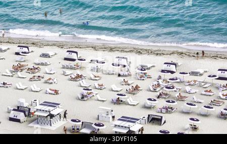 Sonnenanbeter entspannen sich am Sandstrand von Miami Florida Stockfoto