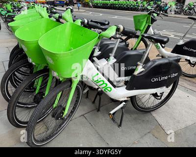 London, Großbritannien - 10. September 2025; viele Lime-Elektrofahrräder mit grünen Körben auf Londoner Bürgersteig Stockfoto