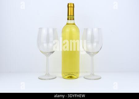 Weißweinflasche zentriert zwischen zwei leeren Gläsern auf weißem Hintergrund, saubere Studiokomposition für Gastfreundschaft, Verkostung, Menü, Feier und b Stockfoto