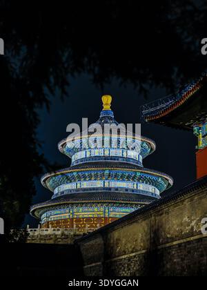 Ein majestätischer alter chinesischer Tempel, der in einem niedrigen Winkel vor einem dunklen Himmel gefangen wurde und seine komplexe Architektur und sein kulturelles Erbe hervorhebt. Stockfoto