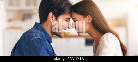 Ein Paar teilt tagsüber einen Moment der Verbindung in einer hellen Küche Stockfoto
