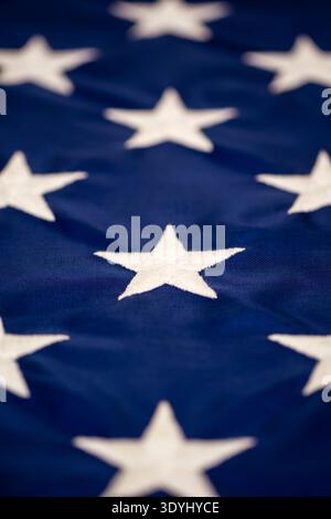 Makrodetail mehrerer weißer gestickter Sterne auf dem blauen Feld der amerikanischen Flagge - ein auffälliger Blick auf patriotische Nähte und Stoffstruktur Stockfoto