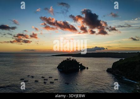 Farbenfroher Sonnenuntergang über der Silhouette der Insel und den Touristenbooten in Crystal Bay, Bali Stockfoto