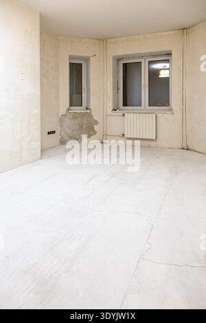 Vorbereitetes Zimmer mit rauer Oberfläche, ohne Bodenbelag, Farbe und Tapeten während der Renovierung der Stadtwohnungen Stockfoto