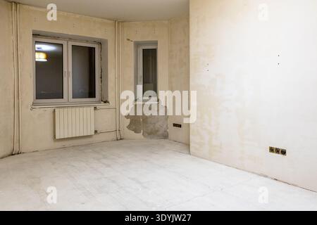 Betonzimmer mit rauer Oberfläche, ohne Bodenbelag, Farbe und Tapeten während der Renovierung der Stadtwohnungen Stockfoto