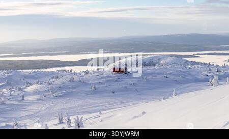 Reisen Sie in die Oblast Murmansk in Russland in der winersaison - aus der Vogelperspektive auf den verschneiten Hügel mit Wohnmobil balok, isoliertem Anhänger auf dem Läufer Stockfoto