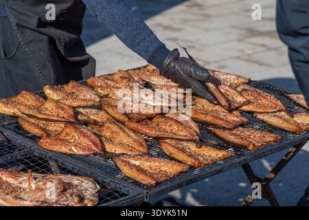 Nahaufnahme von geräucherten Fischfilets auf einem Grill oder Trockenregal auf einem Bauernmarkt in Vilnius, Litauen, verzehrfertig Stockfoto