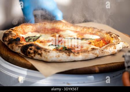 Pizza Margherita mit Tomatensauce, frischem Mozzarella und Basilikumblättern auf einem Holzbrett Stockfoto