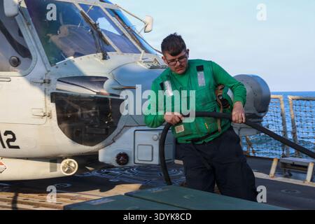 Ein Seemann der US Navy trägt ein externes Netzkabel auf das Flugdeck an Bord des Lenkraketenzerstörers der Arleigh-Burke-Klasse USS John Finn (DDG 113), um die Flugquartiere im US-Zentralkommando zur Unterstützung der Operation Epic Fury am 03. März 2026 vorzubereiten. (Foto US Navy) Stockfoto