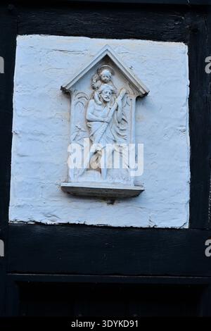 Relief des heiligen Christophorus, der Christuskind auf einer Fachwerkwand trägt Stockfoto