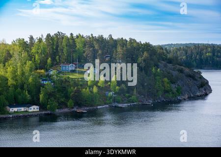 Bewaldete Insel mit Küstenhäusern im Stockholmer Archipel an der Ostseeküste im Stockholmer County, Schweden Stockfoto