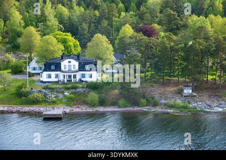 Villa am Wasser an der bewaldeten Inselküste im Stockholmer Archipel im Stockholmer County, Schweden Stockfoto
