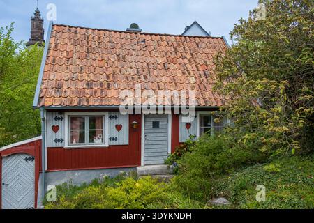 Traditionelles rotes Holzhaus mit gekacheltem Dach und Garten in der Altstadt von Visby, Visby, Schweden Stockfoto